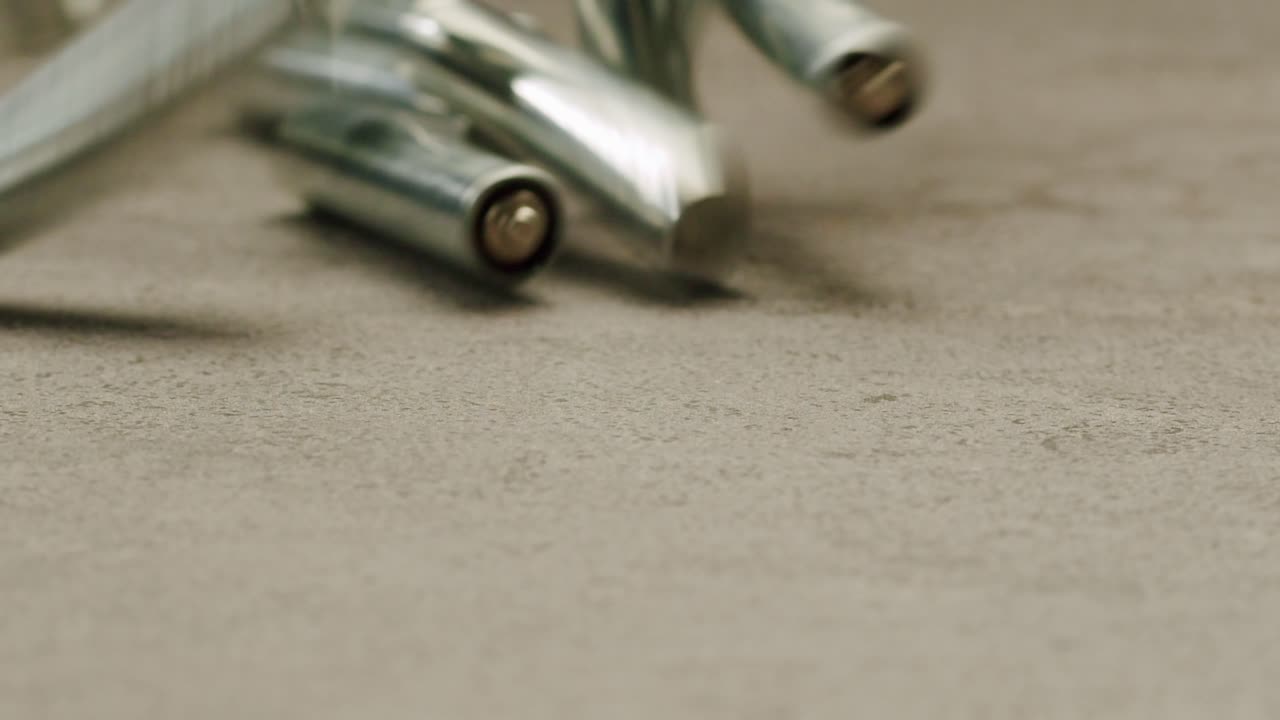 Silver batteries AA and AAA on black background close-up. Double-A battery is a standard size single cell cylindrical dry battery. Batteries are common in portable electronic devices. An AA battery is composed of a single electrochemical cell that may be either a primary battery or a rechargeable ba