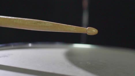 super close up slow motion of a drum stick hitting a snare drum multiple times and bouncing off the snare