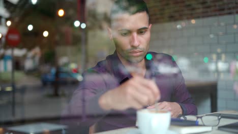 hispanic businessman with hot drink resting in cafeteria