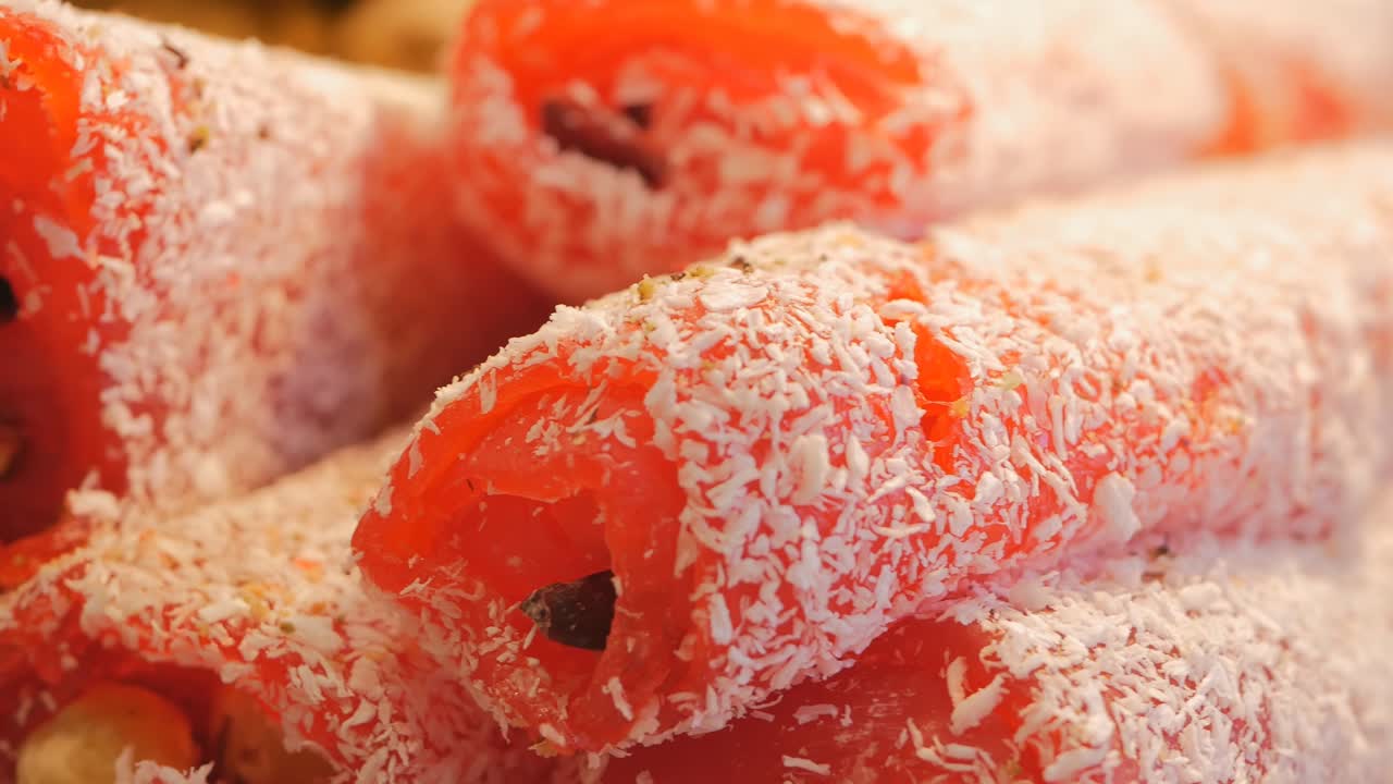 red Turkish delight with wild berries and coconut. Oriental sweets are the best in the spice market in Istanbul. Dolly video, close-up.