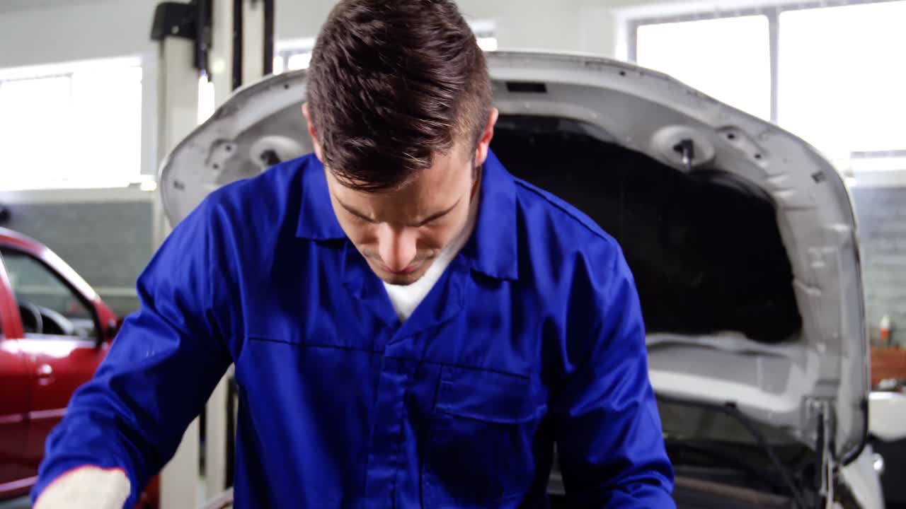 mecánico comprobando las piezas de un coche