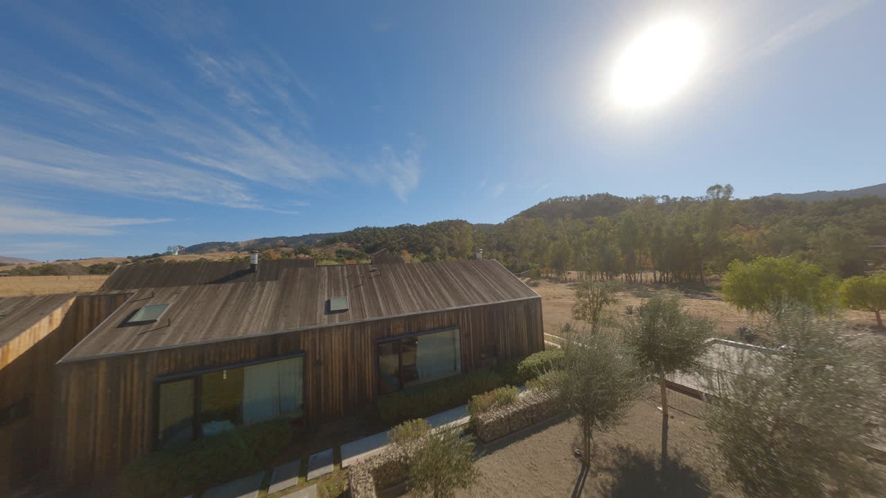 Desert beast Rezvani tank roaring on dirt road featuring trees and highly developed resting place in sunny day