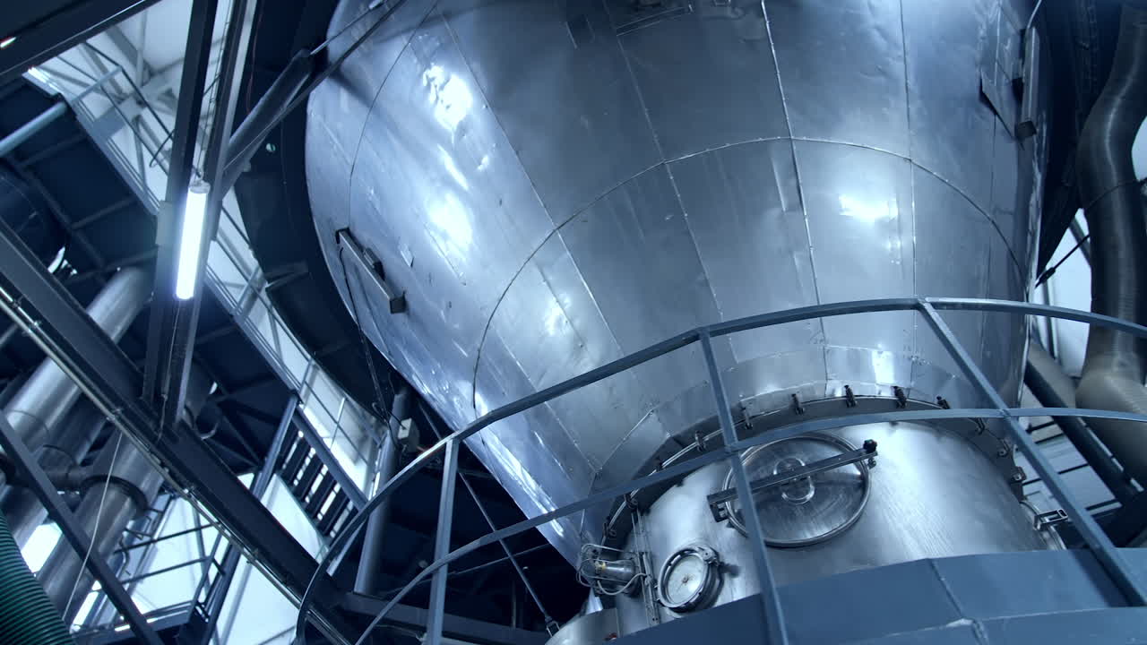 Tank at milk factory. Dairy factory industrial equipment with metal tubes