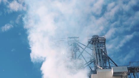 industrial building emitting large amounts of smoke or steam into the sky