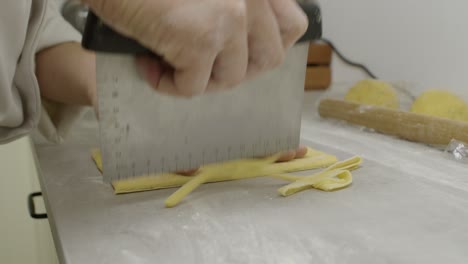 cutting off and forming the pasta dough with kitchen knife