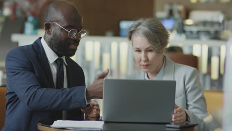 business partners using laptop in restaurant