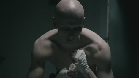pale bald skinny man badnages his hands in the creepy old bathroom at night