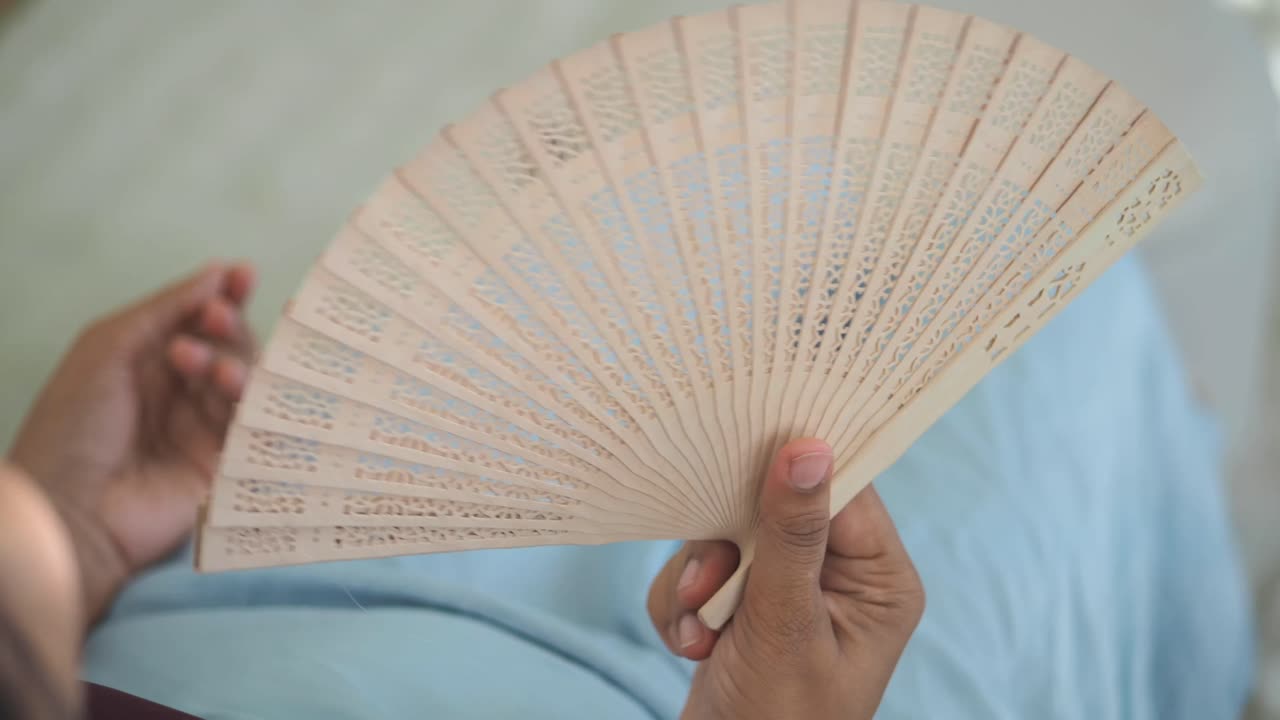 Hand holding a wooden fan