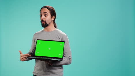 creador de contenido tecnológico que hace marketing de influencia usando una computadora portátil de pantalla verde