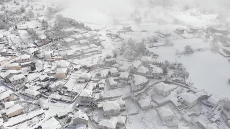 Drohnenvideo-über-Dem-Dorf,-Das-Im-Nebligen-Winter-Schneit