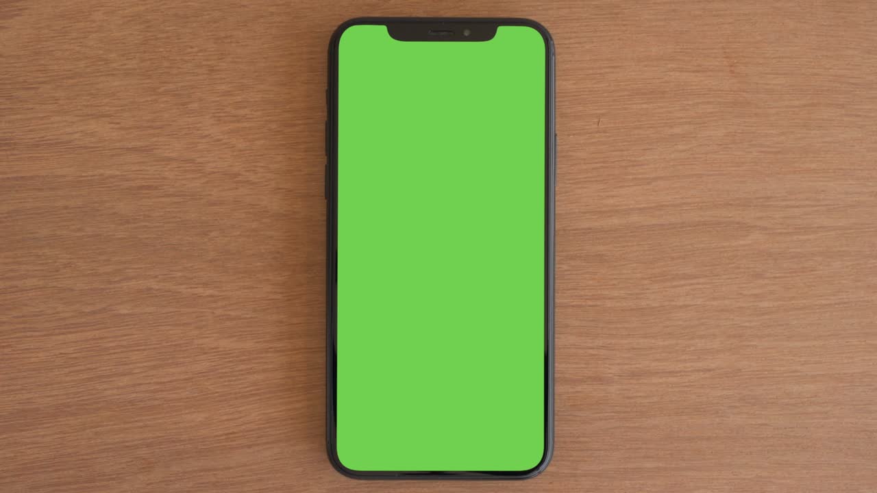 Smartphone appoggiato su tavolo di legno.
