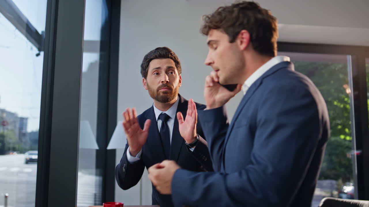 Man boss arguing cellphone standing business partner at cityscape hall closeup