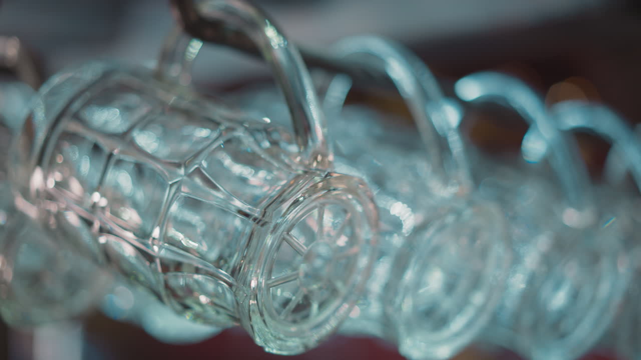 tazas de vidrio texturizadas para bebidas de cerveza cuelgan en el estante en el pub