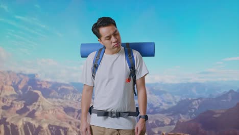 asian male hiker with mountaineering backpack shaking his head and making unsatisfied face while traveling at the top of mountain