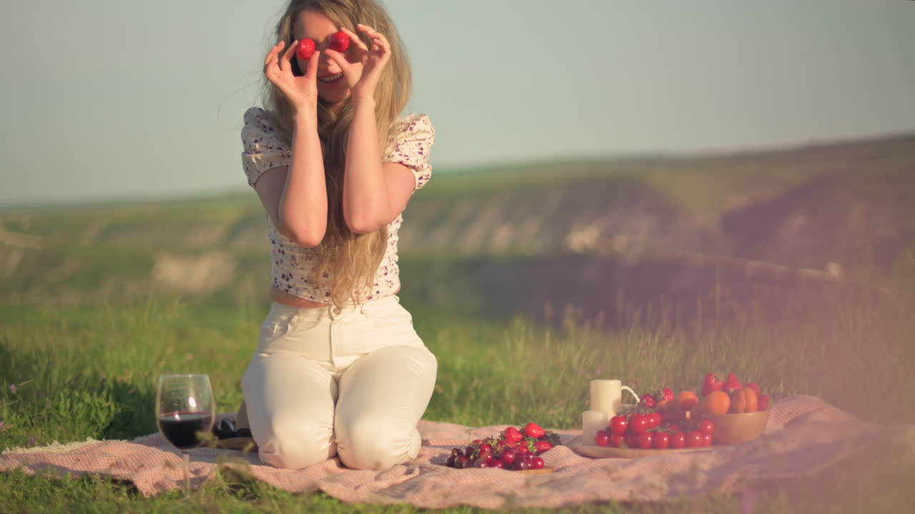 Woman playing with fruit at a picnic in nature