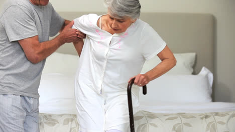 Middleaged-man-helping-his-wife-to-stand-up