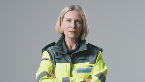 Studio-Portrait-Of-Serious-Mature-Female-Paramedic-Against-Plain-Background