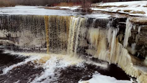 Drohne-Nähert-Sich-Malerischer-Winterschneelandschaft,-Eisweiße-Landschaft,-Estland,-Jägala-Wasserfall,-Jägala-Fluss,-Natürliche-Luftaufnahmen