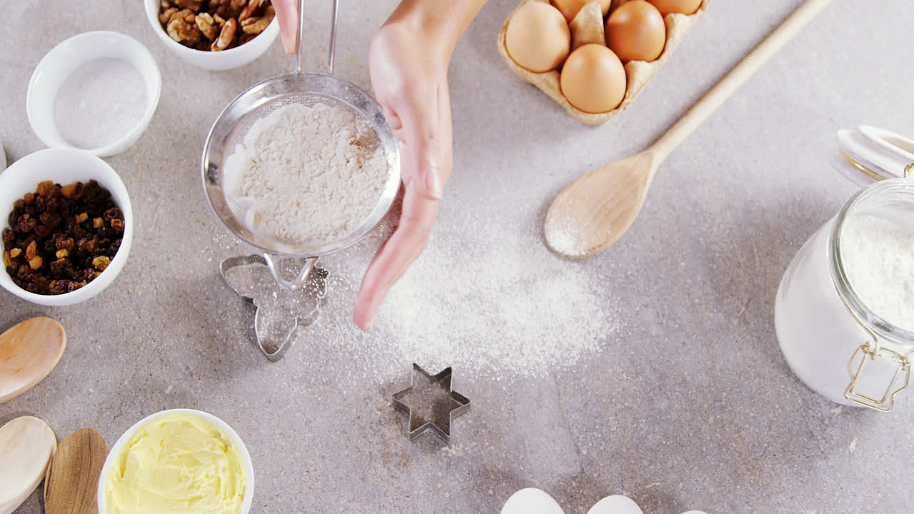 Woman staining flour in sieve 4k