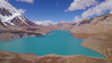 el circuito de annapurna en nepal tiene el lago de mayor altitud del mundo. vista hipnotizante del tiempo soleado, nubes, montañas, nieve, lago azul y cielo, tilicho manag drone shot 4k