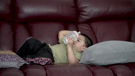 Seitenansicht-Eines-Kleinen-Jungen,-Der-Auf-Der-Couch-Mit-Feeder-Liegt