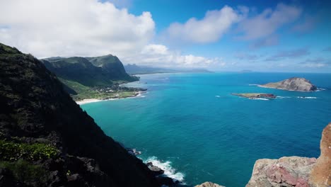 timelapse of oahu, hawaii shoreline high up from peak of makapuu point lighthouse trail on a bright blue day with beautiful whispy white clouds passing by