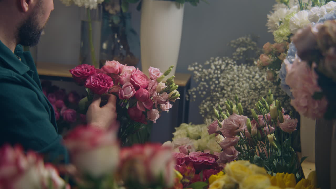 el florista agrega ramas a las hermosas flores