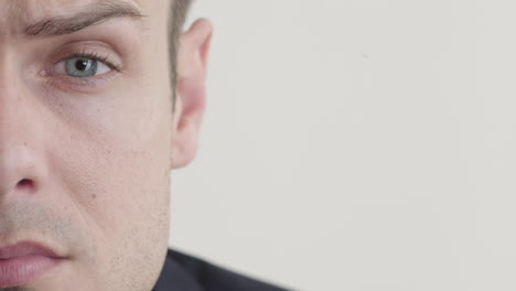 close-up-young-man-making-faces-looking-angry-expression-showing-emotion-on-white-background-half-face