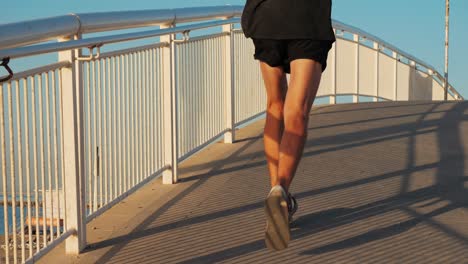 man running on a coastal bridge