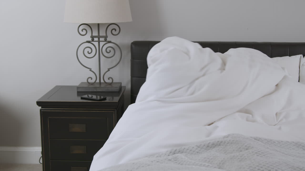 아침에 일어나 이불을 던지는 중년 남성