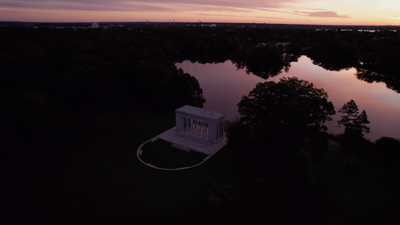 las imágenes circulares de drones durante una puesta de sol naranja muestran el templo de roger williams park a la música
