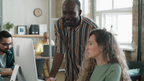 black man and caucasian woman discussing business project on computer