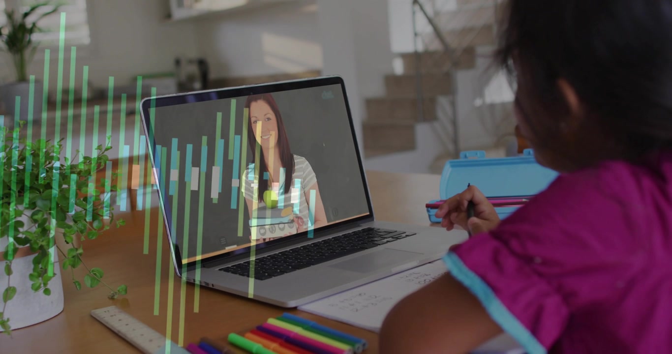 Child writing at desk while laptop linking, teacher appearing onscreen with books aiding learning
