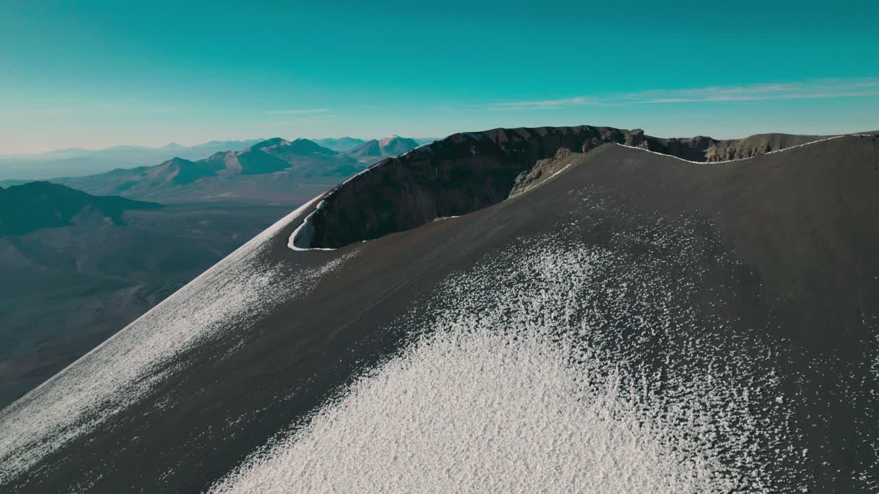 Orbiting drone shot looking into the summit crater of Parinacota Volcano. Rugged rim and expansive Altiplano landscape in Sajama National Park