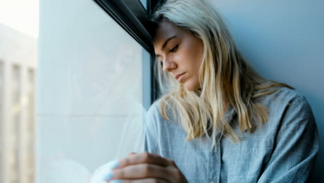 Worried-woman-sitting-near-window-4k