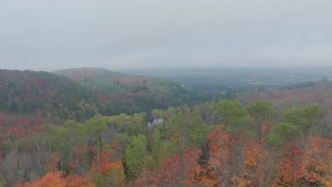 Aerial-View-of-Early-Autumn-Forest-with-Vibrant-Foliage-and-Serene-Lake-Centerpiece