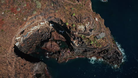 drone aéreo disparado sobre la cueva de poris de la candelaria en la isla de la palma, islas canarias, españa. vacaciones de verano exclusivas propiedades privadas ubicadas dentro de una cueva a lo largo de la escarpada costa.