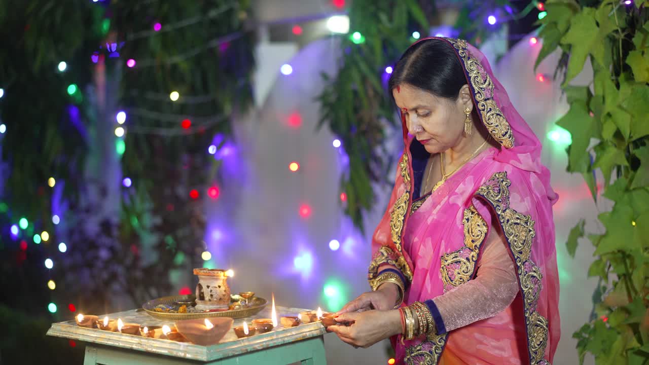 una mujer encendiendo una lámpara