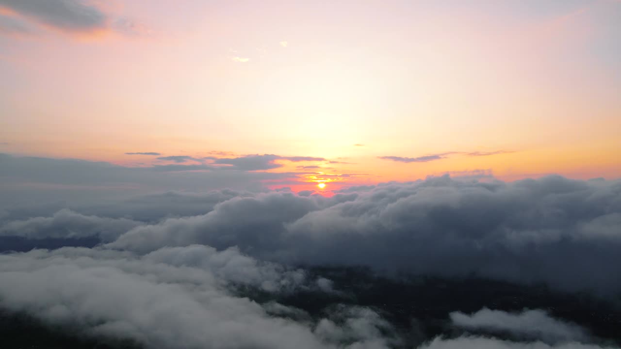 Veduta aerea del sole che sorge sopra le nuvole.