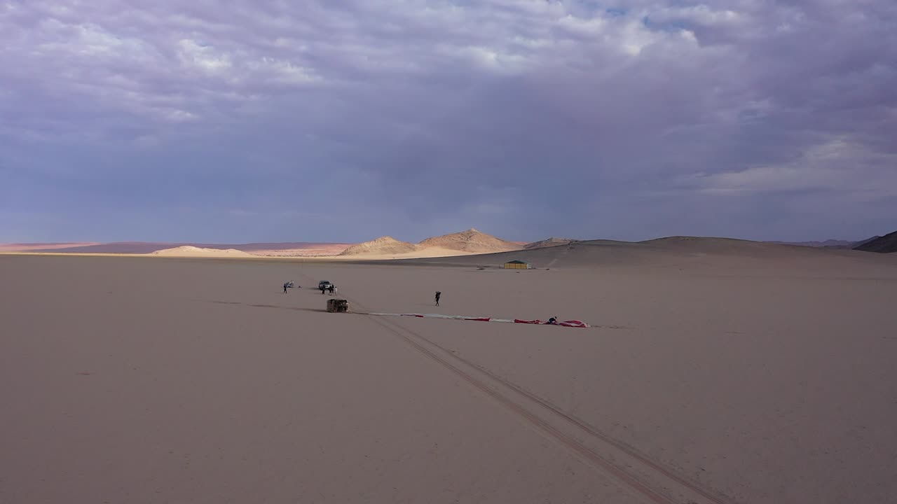 사막 에서 풍선 을 발사 할 준비 를 하고 있는 몇 명 의 남자 들 의 위 에서의 전망