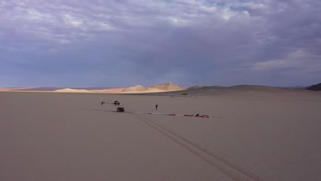 Blick-Von-Oben-Auf-Einige-Männer,-Die-Sich-Darauf-Vorbereiten,-Einen-Ballon-In-Der-Wüste-Zu-Starten