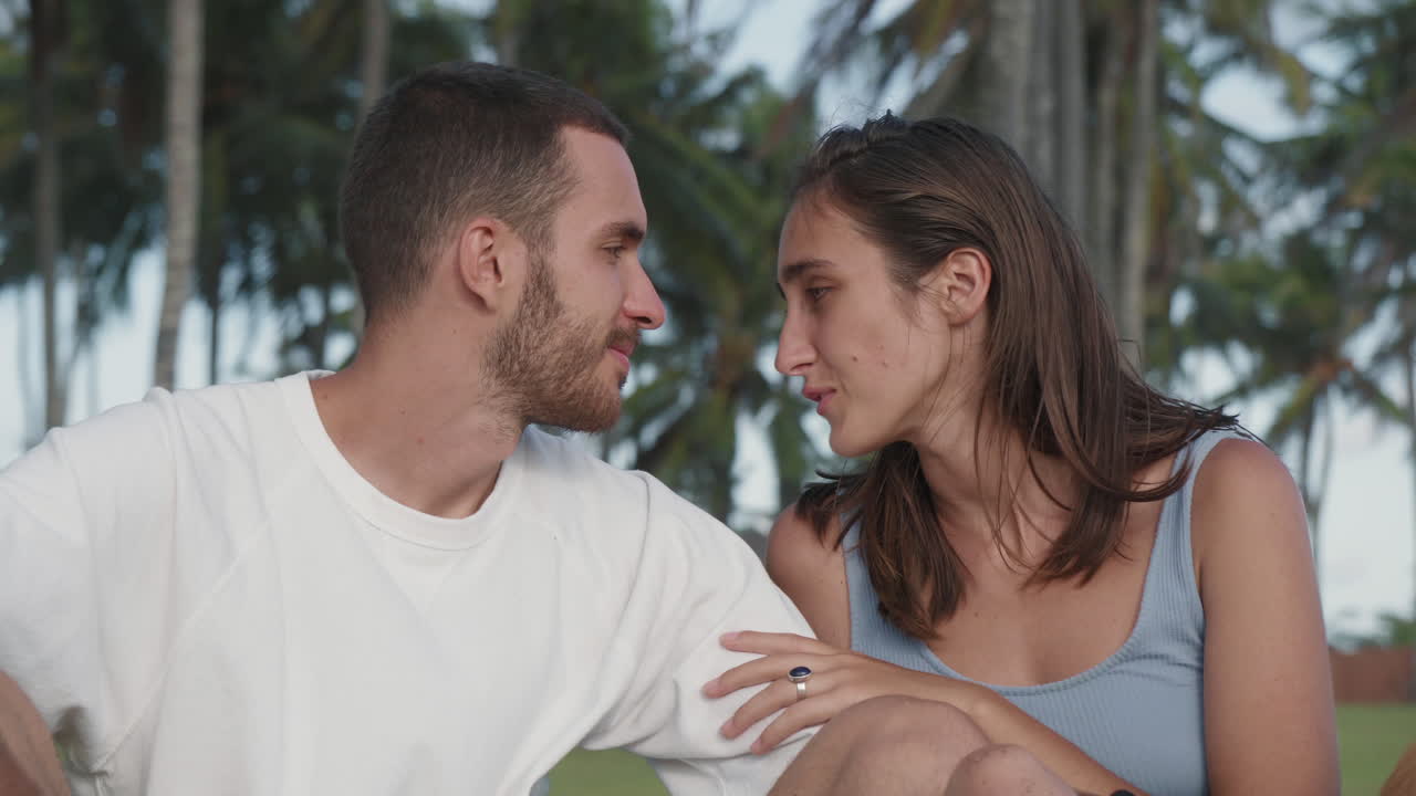 una pareja enamorada hablando y besándose.