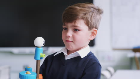 primer plano de un niño de escuela primaria construyendo un juguete en un aula, centrarse en el primer plano