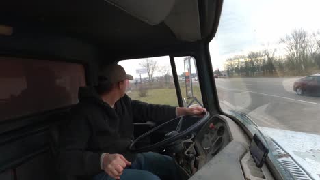 Young-man-driving-old,-1972-dump-truck,-interior-view