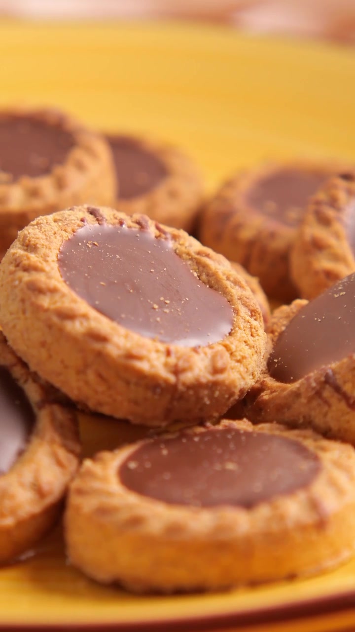 Primo piano di deliziosi biscotti ripieni di cioccolato su un piatto giallo