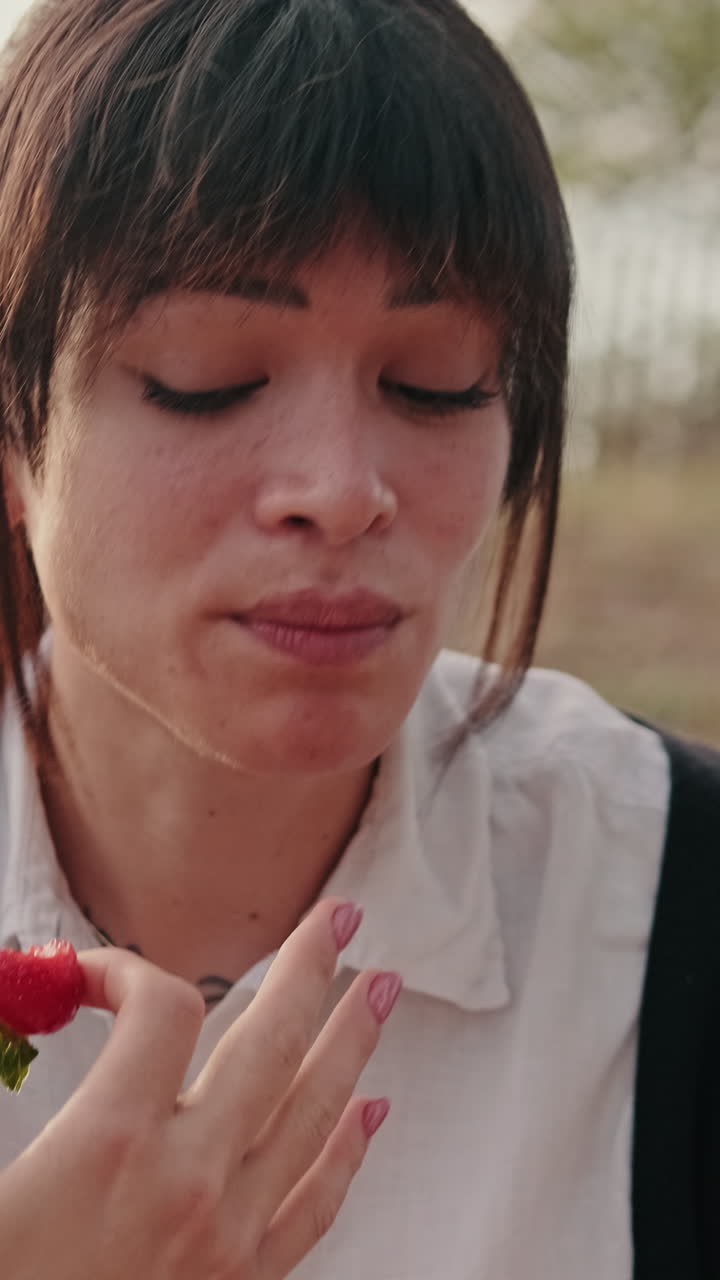 Happy Woman Eats Strawberry at a Picnic