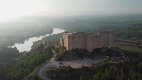 arriving at miravet castle on banks of the ebro river on a misty morning