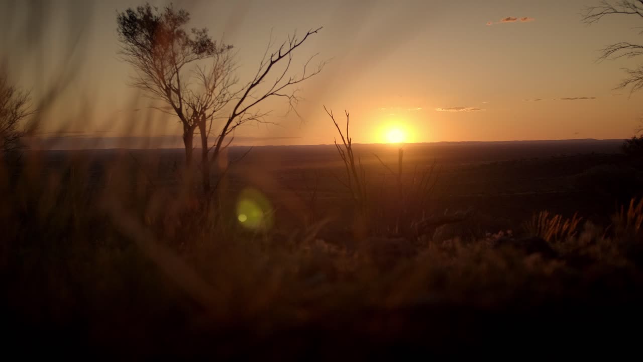 hermosa puesta de sol sobre las llanuras australianas secas de color rojo anaranjado en el desierto