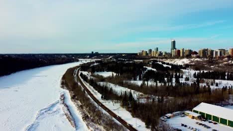 sobrevuelo aéreo de invierno el club royal glenora al lado del parque victoria pista de patinaje sobre hielo junto al bosque al lado del río saskatchewan norte cubierto de nieve con el horizonte del horizonte del condominio perla 1-2