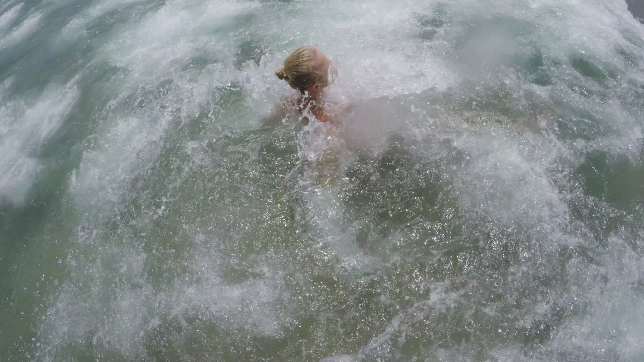 바다의 파도가 수영하는 여자에게 부히고